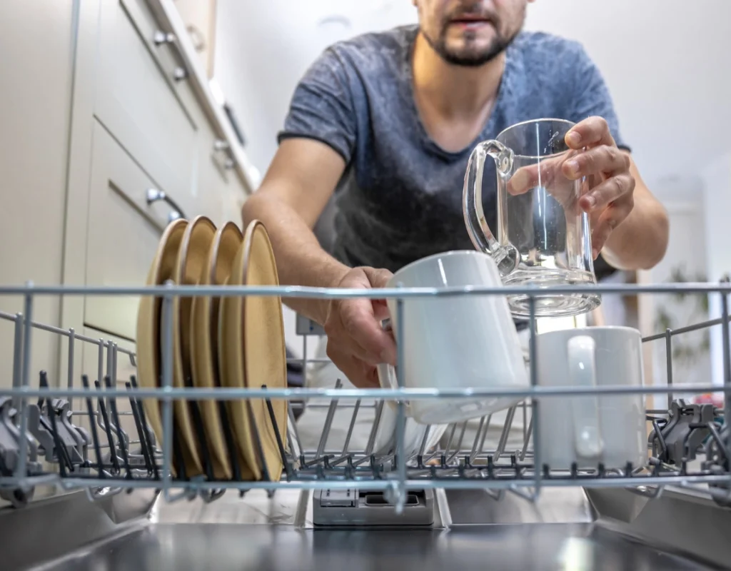 Carlsbad CA plumber performing professional dishwasher installation with secure water line connections.